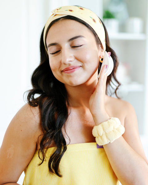 Woman using Next Stop Glowing Beauty Skincare products. 