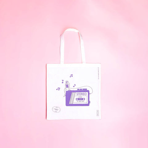 White tote bag with a purple cassette tape design on a pink background